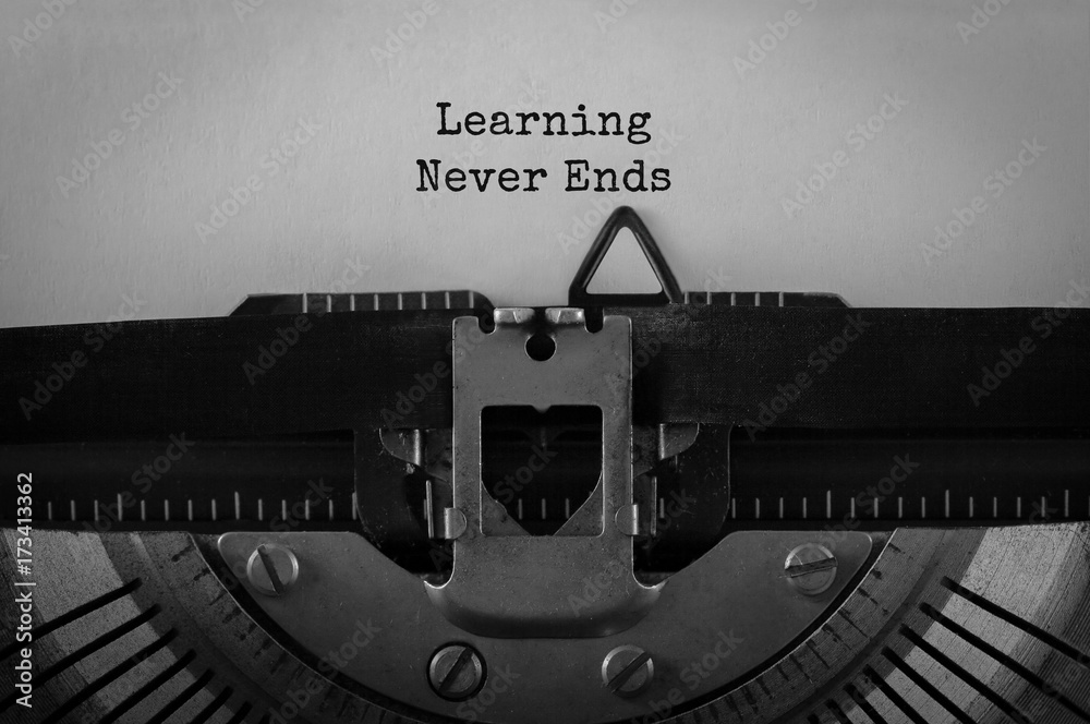 Fototapete text learning never ends typed on retro typewriter