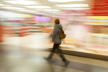 Woman walking against shop window