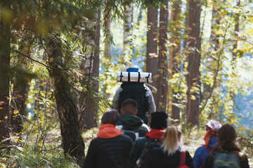 Backpacking and camping - tourists walking in autumn forest