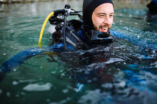 Male diver swimming at water surface