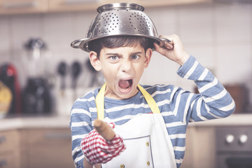 Funny angry boy chef shouting in the kitchen