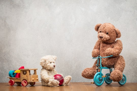 Retro Teddy Bear toys family: parents playing with child front concrete wall background. Vintage instagram old style filtered photo