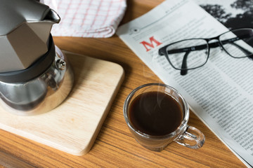 Hot Coffee in Espresso Cup with Magazine on the Table