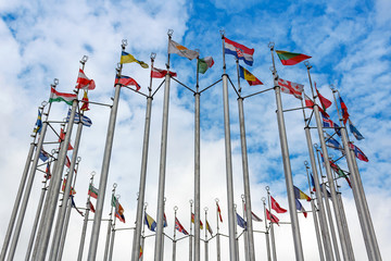 Flags of different countries on blue sky background