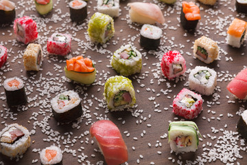 Set of sushi, maki and rolls with sesame on wooden rustic background