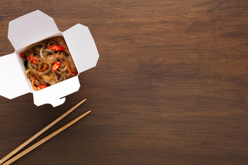 Asian food in delivery box on wooden table