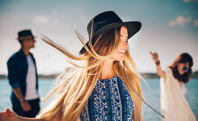 Group of friends dancing and celebrating on beach, boho party © leszekglasner