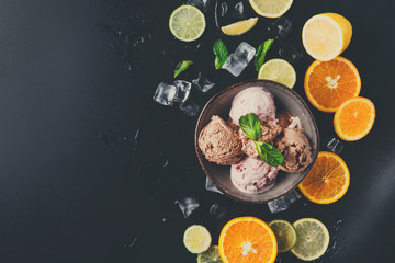 Ice cream scoops in bowl on black background