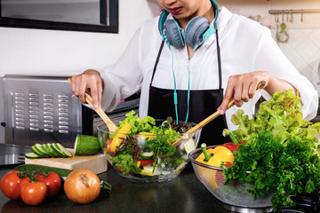Young happiness Woman Cooking vegetables salad in the kitchen, Healthy food concept