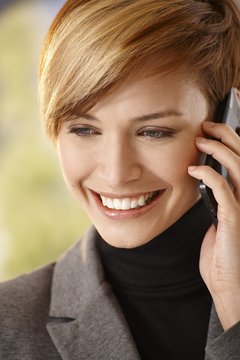 Closeup of happy young woman talking on mobile