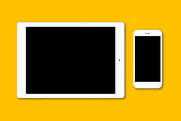 Modern smart phone and digital tablet isolated over yellow surface. Contemporary gadgets with blank screen for your advertisment or promotional text. Two objects. Technology concept