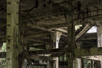 Old dirty broken ruined abandoned building among Bog, Facade ruins of industrial factory
