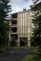 Old dirty broken ruined abandoned building among Bog, Facade ruins of industrial factory