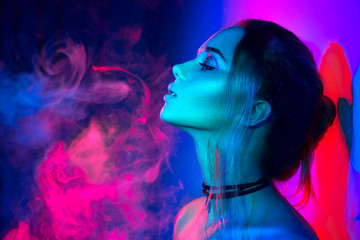 Beautiful sexy girl with trendy make-up in colorful bright lights - obrazy, fototapety, plakaty