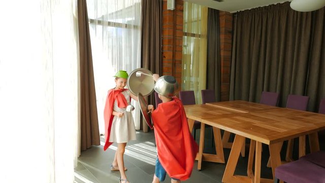 Children play superheroes. Children play with kitchen utensils. Children's fantasy.