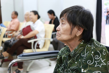 Old Asian woman sitting in wheelchair in hospital.