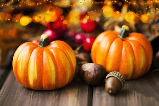 Fall festive decoration with pumpkins, chestnuts , acorns and brighty lights, halloween celebration