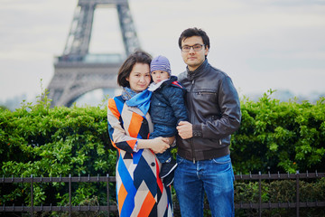 Happy family of three in Paris near the Eiffel tower