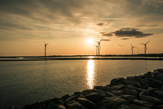 Windmills in sunset by the sea