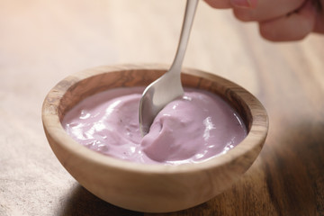 eating blueberry yogurt from wood bowl