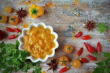 sauce yellow curry, fresh paprika pepper, cherry tomatoes, parsley and spices on old wooden table