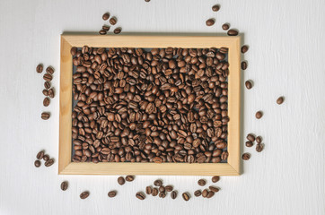 Coffee beans in a wooden frame on a white background top view, free copy space