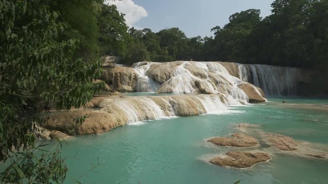 Small beautiful lake with azure water near tropical waterfall in the jungle at sunny summer day