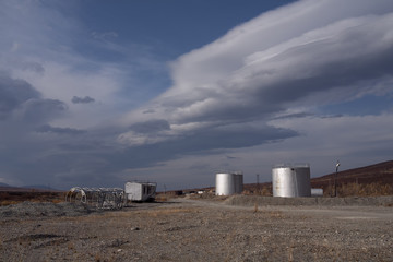 Obraz premium Silver tanks and the sky with lenticular clouds. Polar Urals. Russia.