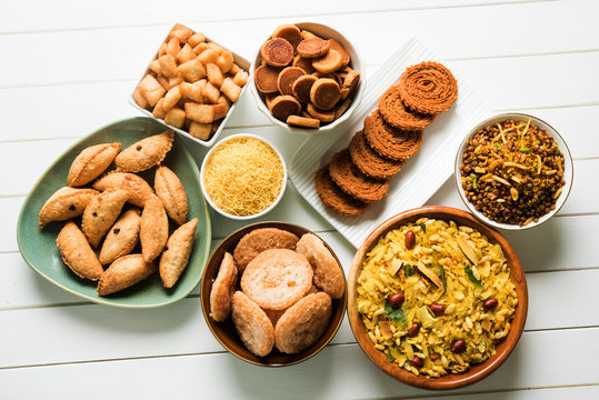 stock photo of  Diwali food or Diwali snacks or Diwali sweets like anarsa, bakarvadi, chakli, sev, bhujiya, shankar pale and chivda or chiwada, karanji, favourite indian diwali recipe