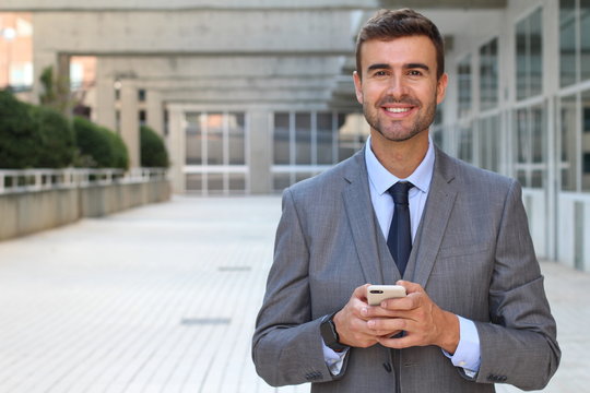 Professional man holding smart phone and smiling isolated 