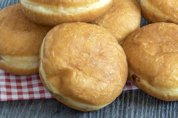 Beignets empil&eacute;s sur serviette &agrave; carreaux et fond sombre