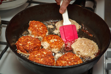 Steaks in a frying pan are roasted on the stove. Fried cutlets. Close-up.
