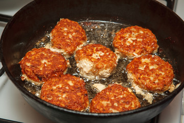 Steaks in a frying pan are roasted on the stove. Fried cutlets. Close-up.