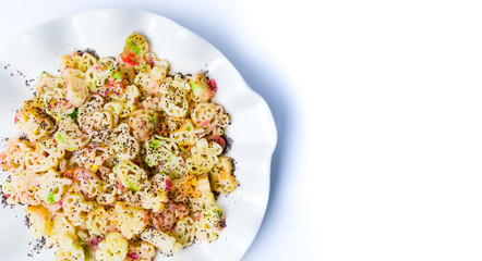 Colorful pasta with poppy seeds on a plate