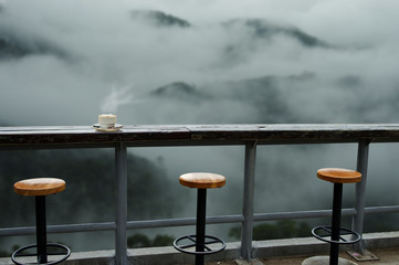 coffee shop in forest fog and coffee cup over wooden table