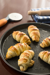 Baked bun rolls on the baking tray with utensils in the background