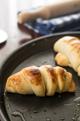 Baked bun rolls on the baking tray with utensils in the background