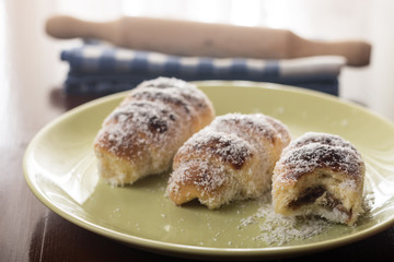Served baked bun rolls with coconut on the plate with blurred background