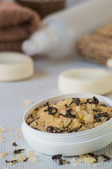   Beauty and hygiene. Body care. Sea salt with aromatic additives in a round white jar, pieces of soap and terry towels on a light background.