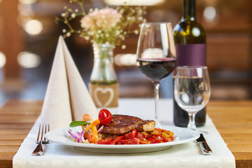 Pork meat with Ratatouille and red wine in a restaurant