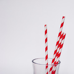 Glass with red and white stiped paper straws. Chrictmas concept