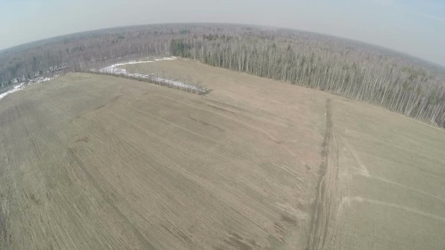 Aerial view of vast farmlands in early spring. Fields among the forest with some snow left, Russia
