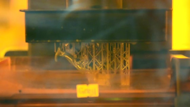 Stereolithography DPL 3d printer create detail and liquid drips, platform slowly move with liquid close-up. Progressive modern additive technology 3D printing, create scaled model by UV polymerization