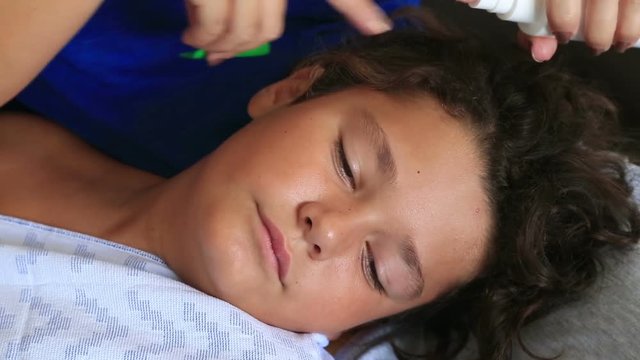Mother treating son's hair against lice