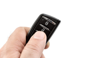 Hand holding car remote control. Isolated on white. Close up.