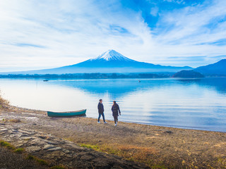 silhouette asia couple traveler 30s to 40s walking and relax at side of lake kawaguchi on morning time with fuji mountain background
