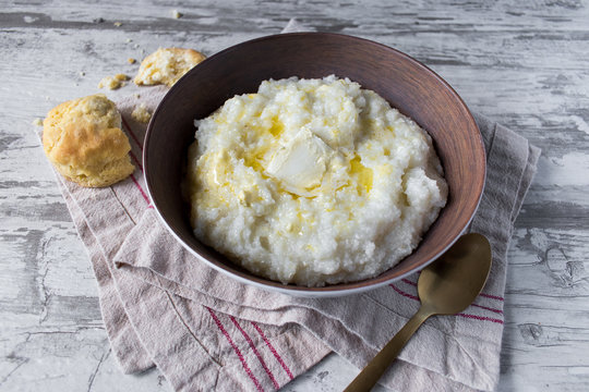 Southern grits with bisquit and butter in rustic setting closeup