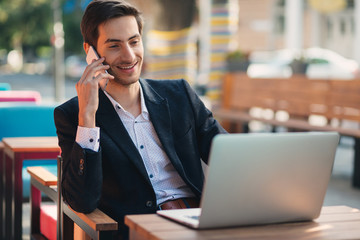 Young entrepreneur working on laptop and phone