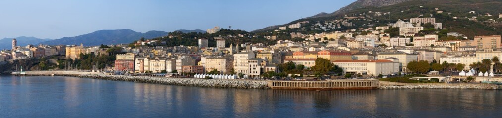 Fototapeta na wymiar Corsica, 03/09/2017: lo skyline di Bastia, la città alla base del Capo Corso, vista dal porto principale dell'isola da cui partono e arrivano traghetti e crociere