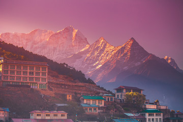 Amazing sunrise view of Namche Bazaar village hotels against mountain peak, Khumbu valley, Nepal. Trekking route to Everest Base Camp, Himalayas. Holidays, sport, recreation. Pink retro vintage toning - obrazy, fototapety, plakaty